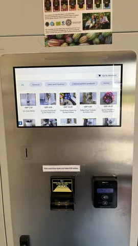 A silver machine with a screen displaying a list of products.