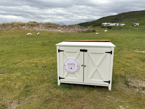 A white box with a sign on it that says Blasta.