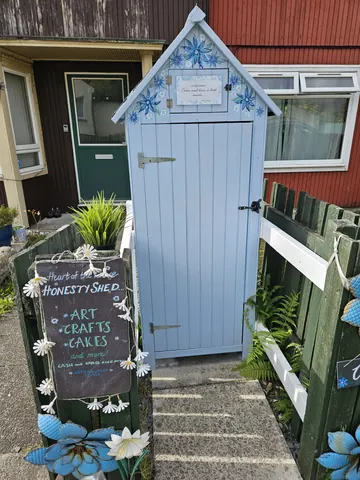 A blue shed with a white sign on it.