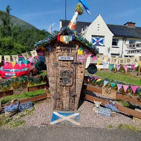 A small wooden structure with a sign that says "Open me" on it.