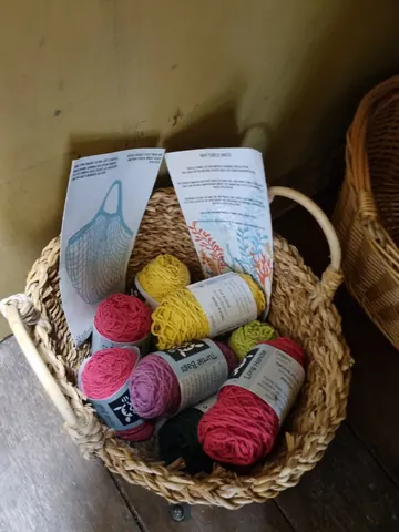 A basket of yarn is sitting on a table.