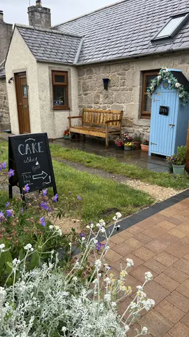 A sign that says "cake" is on the sidewalk.