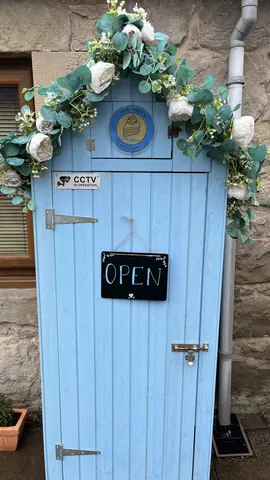 A blue door with a sign that says "open" on it.