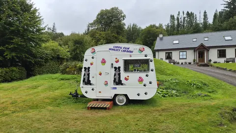 A white trailer with a dog on it.