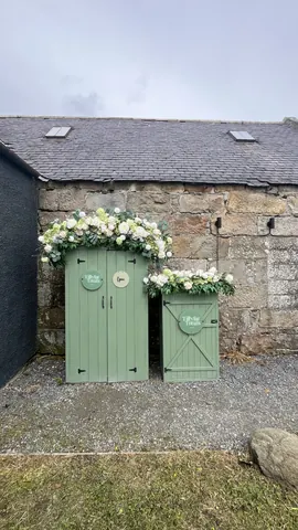 Two green doors with white flowers on them.