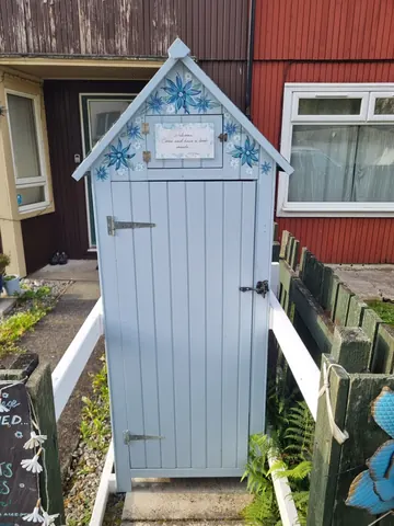A blue shed with a white door.