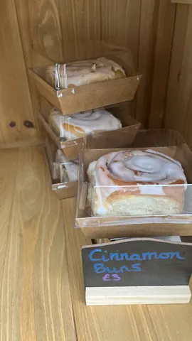 A stack of cinnamon rolls in a display case.