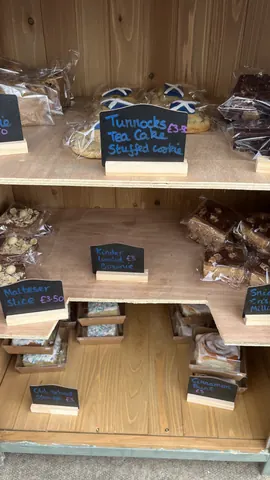 A display of baked goods, including cookies and cakes, is on a shelf.