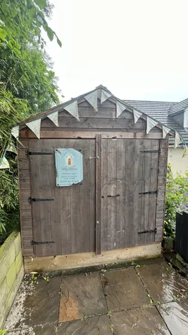 A wooden shed with a sign on it.