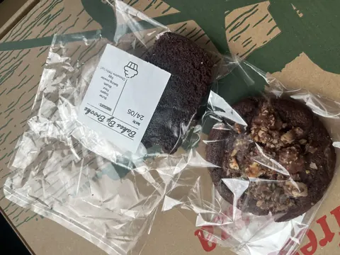 Two chocolate cookies are sitting on a table.