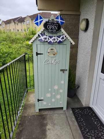 A small blue and white building with a sign that says "Open" on it.