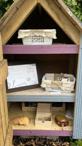 A wooden box with a picture and a basket of items inside.