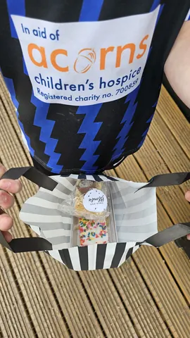 A person is holding a bag that has a cookie in it.
