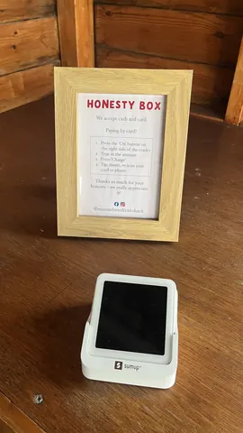 A white cell phone is sitting on a wooden table.