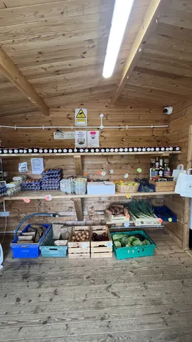 A wooden building with a shelf full of food.