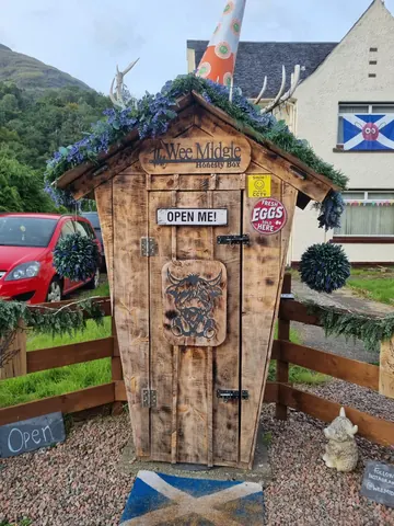 A wooden shed with a sign that says "Open me".