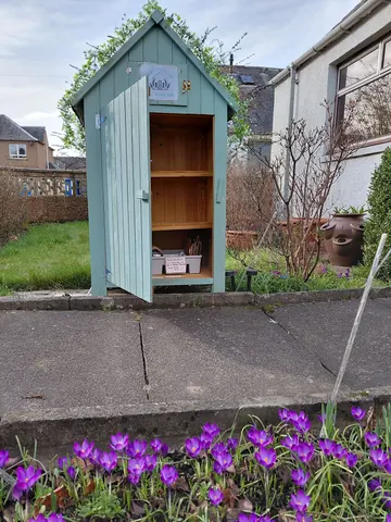 A small blue shed with a white door.