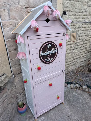 A pink shed with a sign that says "The Amandy Lakes".