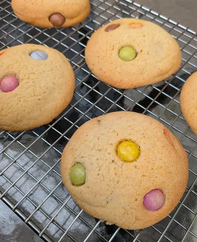 A tray of cookies with different colored sprinkles on top.
