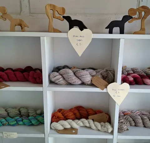 A white shelf with a sign that says "Pure Wool" on it.