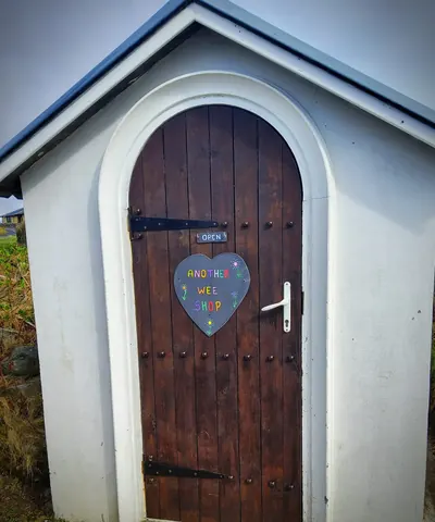 A white door with a heart shaped sign on it.