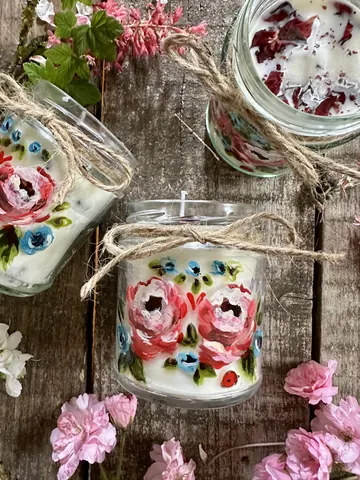 A table with two candles and flowers on it.