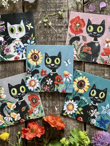 A collection of cat paintings with a flower in the middle.