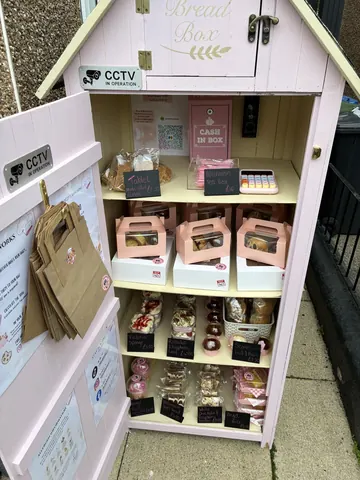 A pink box with a sign that says "Cake in a box".