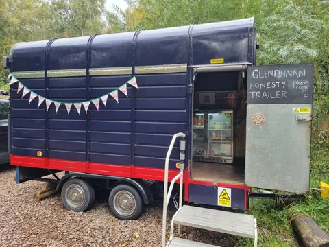 A blue and red trailer with a sign on the side.