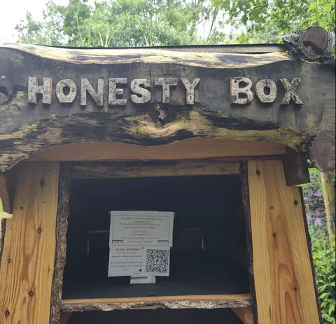 A wooden box with the words "honesty box" written on it.