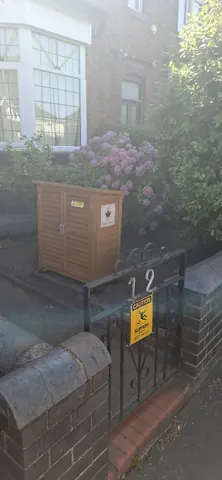 A wooden box with a yellow sign on it.