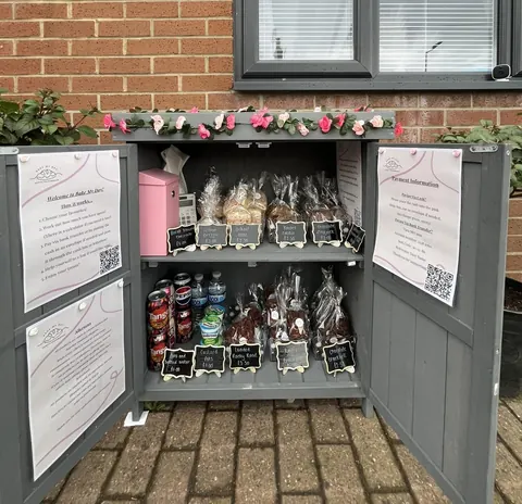A small pink box with a sign on it.
