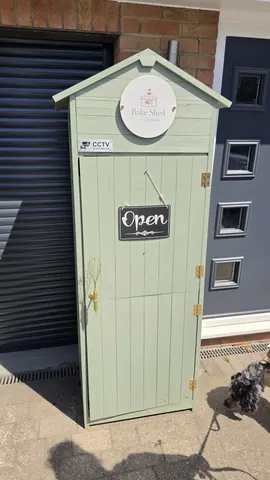 A green door with a sign that says open.