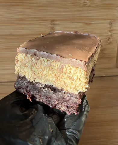 A slice of cake is on a black plastic bag.