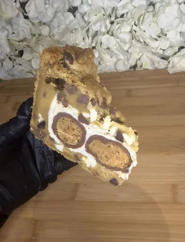 A piece of cake with white frosting and chocolate chips.