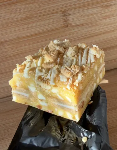A slice of cake with nuts on top.