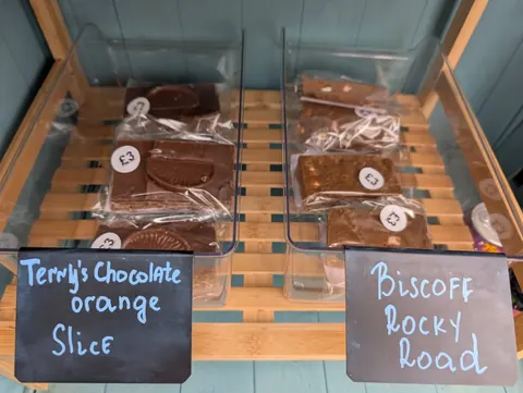 A display case with two trays of chocolate and biscuit orange rocky road.