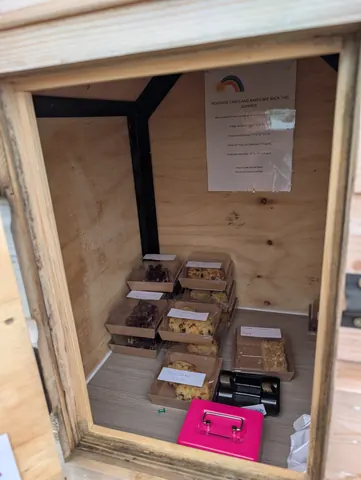 A wooden box with a pink sign on it.