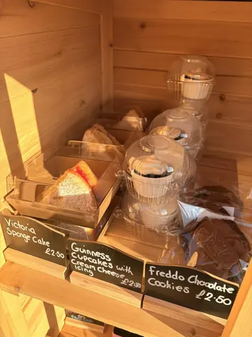 A wooden display case with a variety of food items inside.