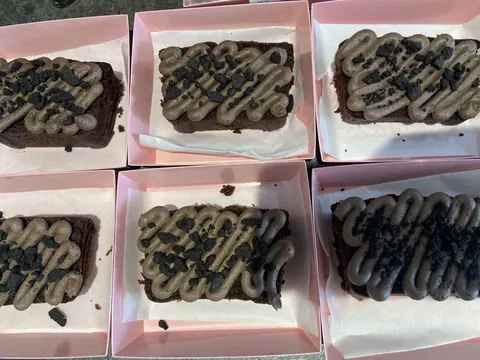 A box of chocolate cake with chocolate chips and caramel drizzle.