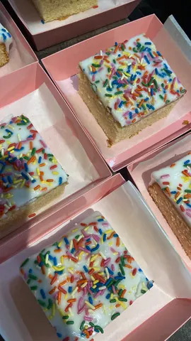 A box of cake with sprinkles on top.
