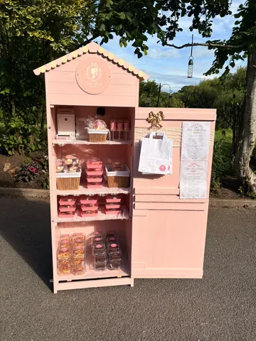 A pink wooden structure with a sign on it.
