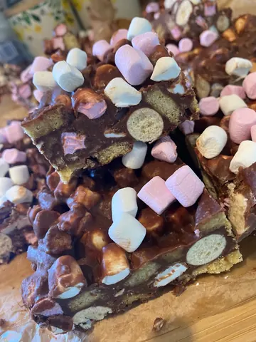 A cake with marshmallows and chocolate on top.