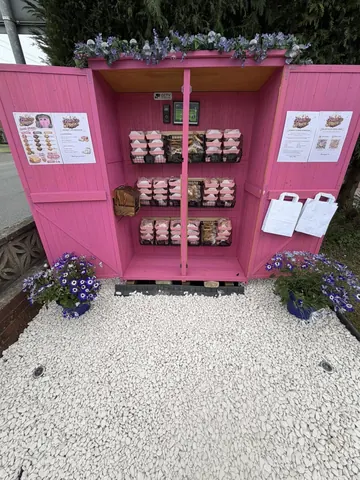 A pink building with a sign that says "Pink Pig" on it.