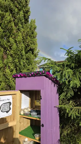 A purple building with a rainbow in the sky above it.