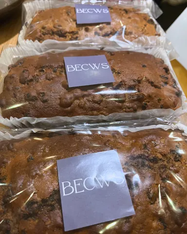 A brown loaf of bread with a white tag that says Becws.