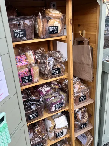 A wooden box filled with various types of cakes.