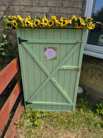 A green shed with a sign on it.