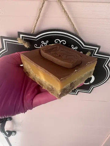 A person is holding a piece of cake.