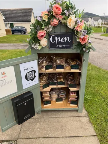 A small wooden box with a sign that says "open" on it.